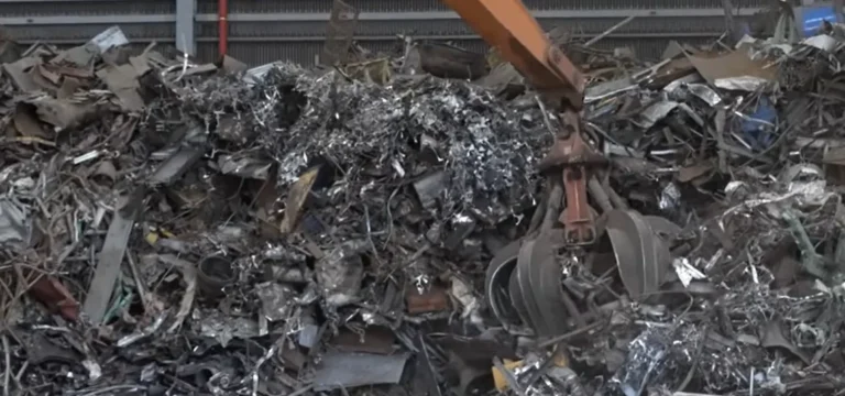 Grapple handling shredded steel and stainless scrap in a recycling yard