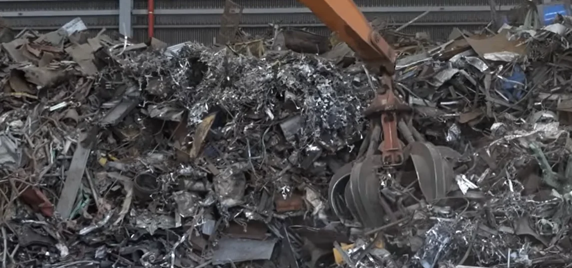 Grapple handling shredded steel and stainless scrap in a recycling yard