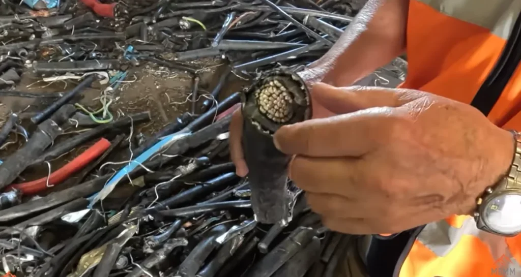 Hand holding cut insulated copper cable scrap