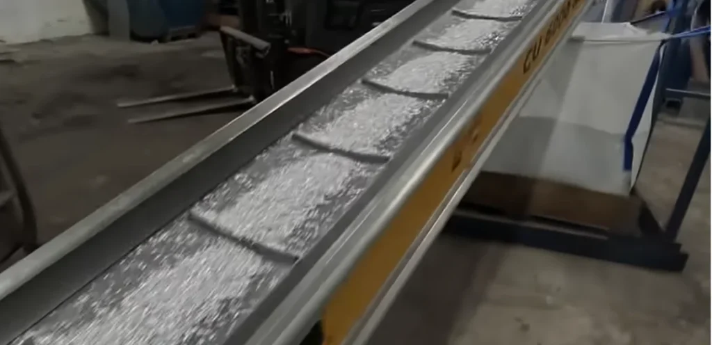 Shredded aluminium scrap moving on a sorting conveyor
